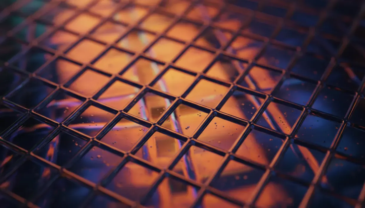 Grille métallique photographiée en gros plan, éclairée de reflets orangés et bleus